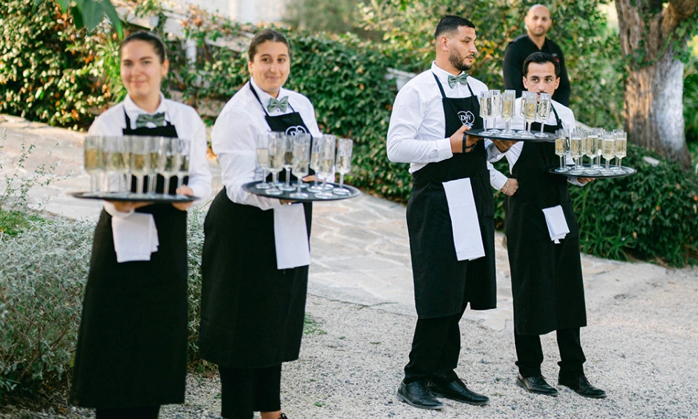 Équipe DV Traiteur, servant du champagne pendant le vin d'honneur mariage à la Bastide du Roy
