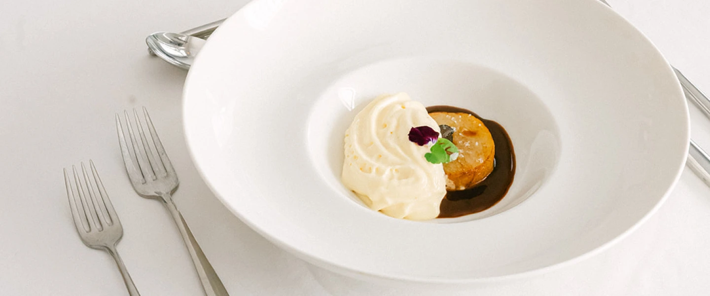 Dégustation traiteur mariage : assiette gastronomique avec de purée, pomme de terre rôtie et jus corsé, dressée en salle