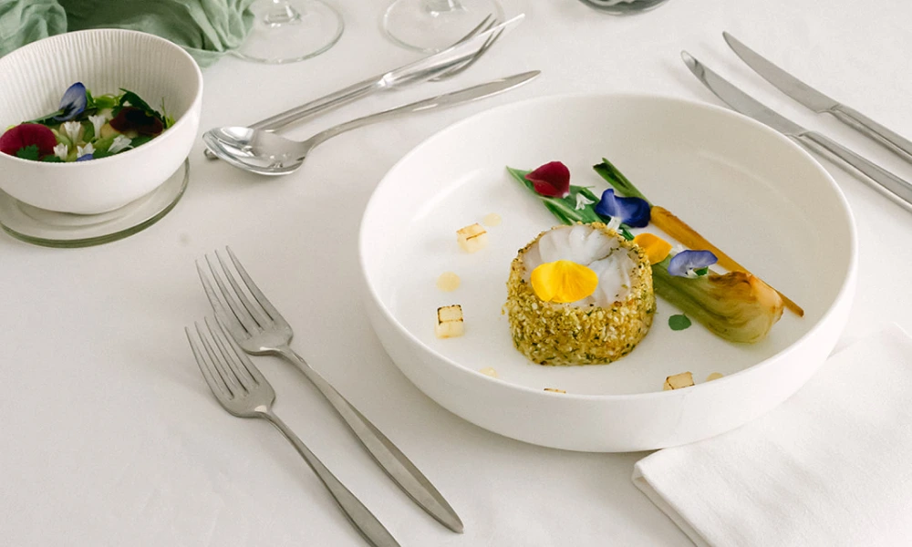Dégustation traiteur mariage : table dressée avec poisson pané aux herbes, fleurs comestibles