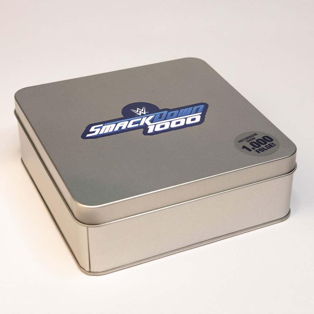 Silberne Metalldose mit SmackDown 1000 Logo – hochwertige Verpackung der Werbebox für das WWE-Jubiläumsmailing.