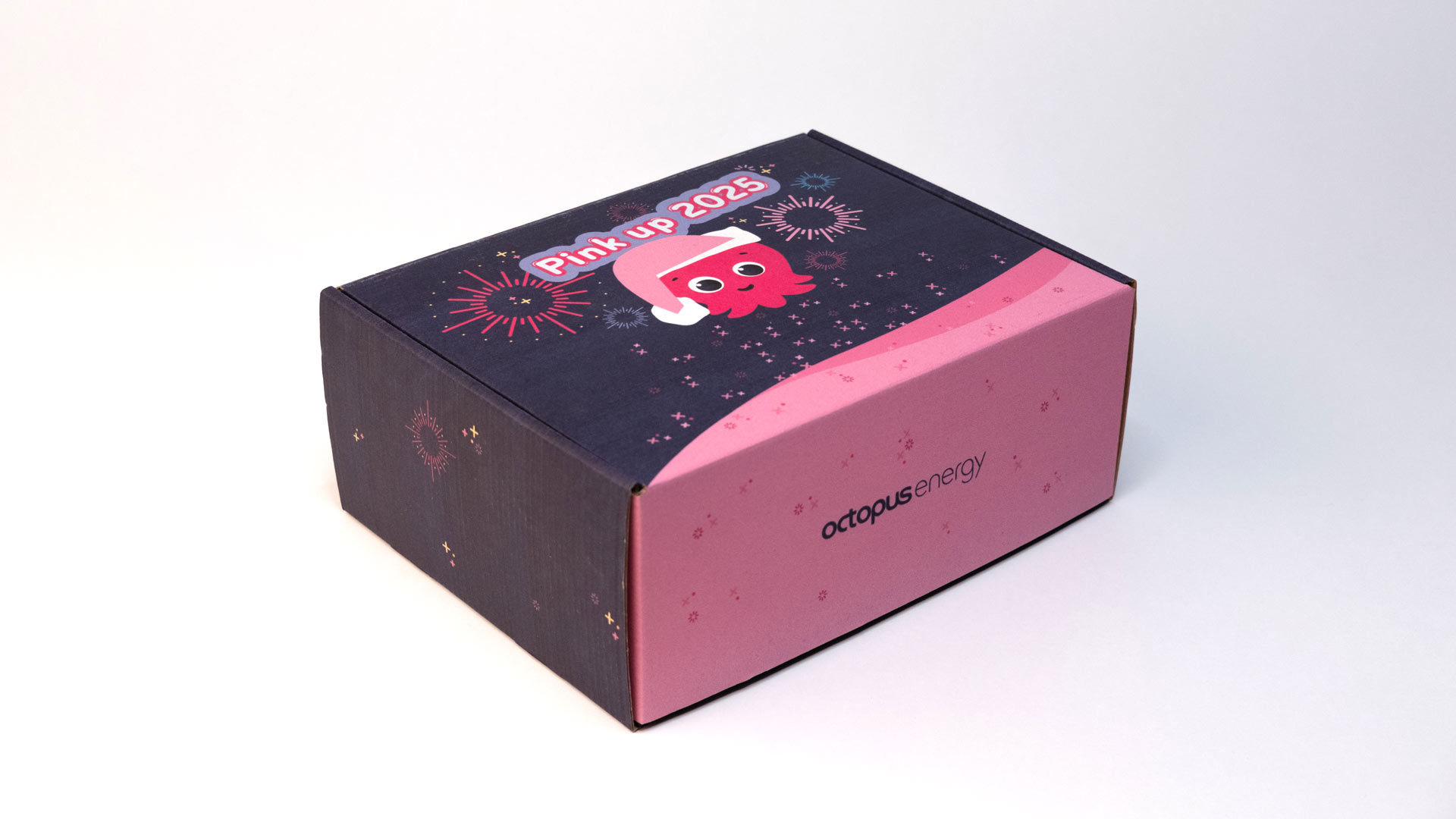 Geschenkbox aus Karton in rosa und dunkelblau.  Aufschrift zum neuen Jahr: "Pink up 2025"