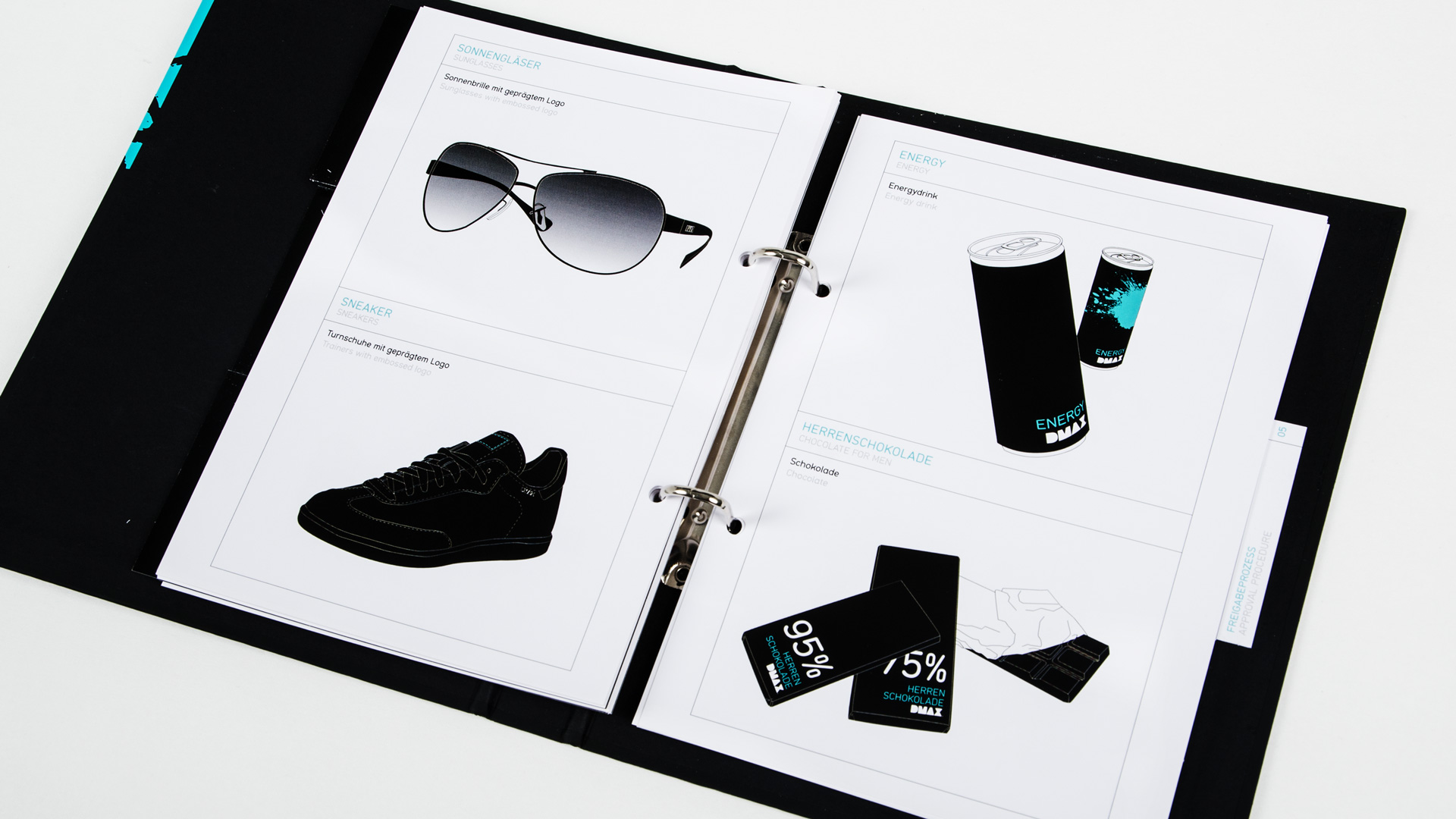 Ein aufgeklappter schwarzer Ordner aus dem Tollkit Koffer mit Motiven wie Sonnenbrille und Energiedrinks im DMAXX Look.