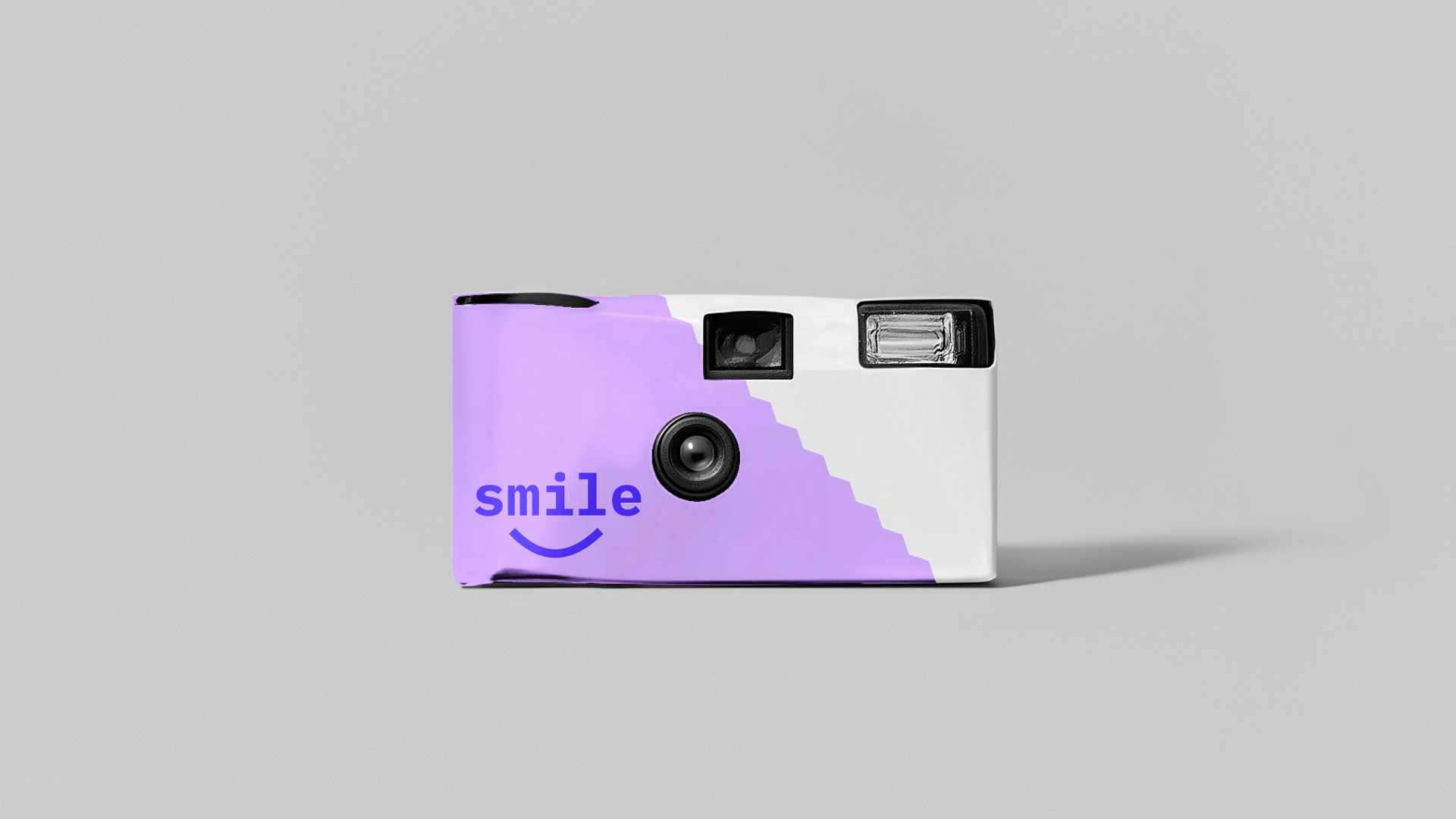 Zum Onboarding eine Einwegkamera als Mitarbeiter Geschenk mit "smile" darauf stehend.