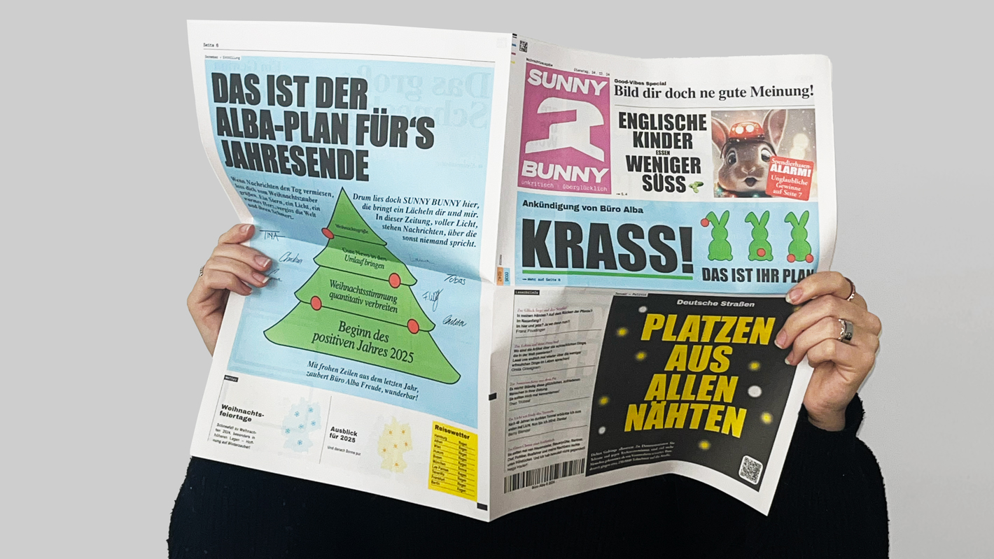 Aufgeklappte Weihnachtszeitung mit positiven Nachrichten darauf, das perfekte kreative Weihnachtsgeschenk für Geschäftspartnern.

 