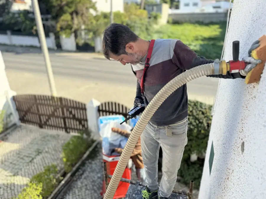 Técnico da EnergyEase a insuflar lã mineral na caixa de ar de uma parede exterior