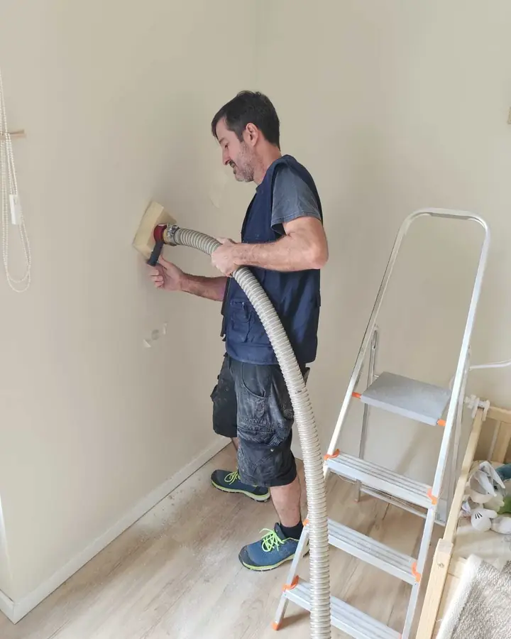Técnico da EnergyEase a insuflar uma parede a partir do interior de um quarto