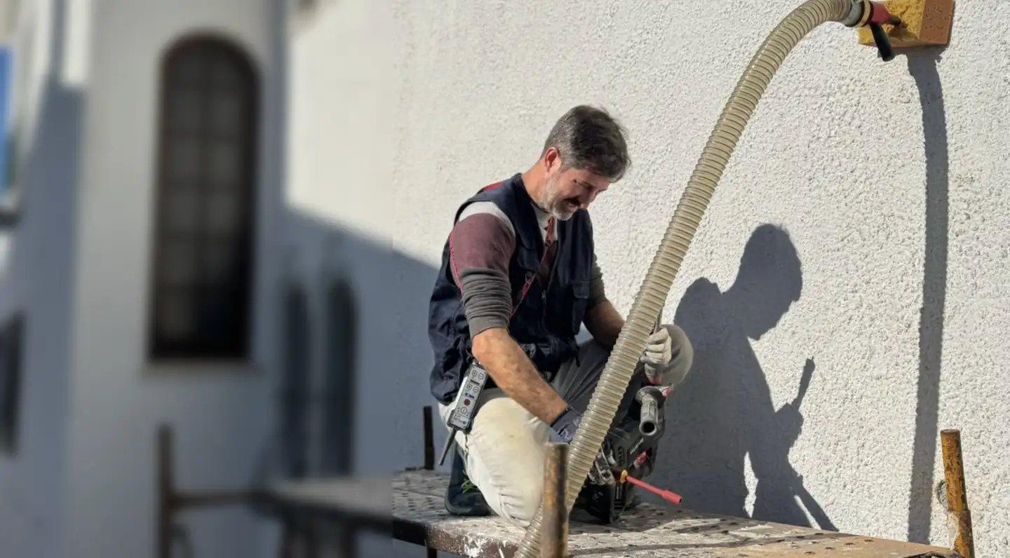 Técnico da EnergyEase a insuflar lã mineral na caixa de ar de uma parede exterior