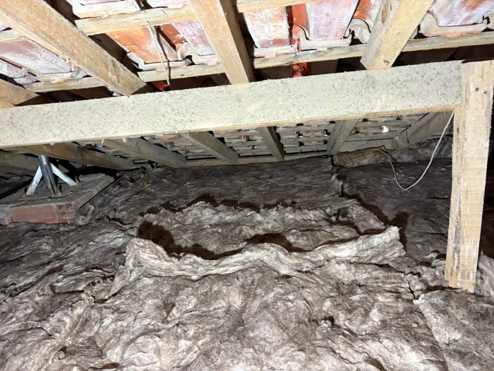 Isolamento antigo e abatido no chão de um sótão