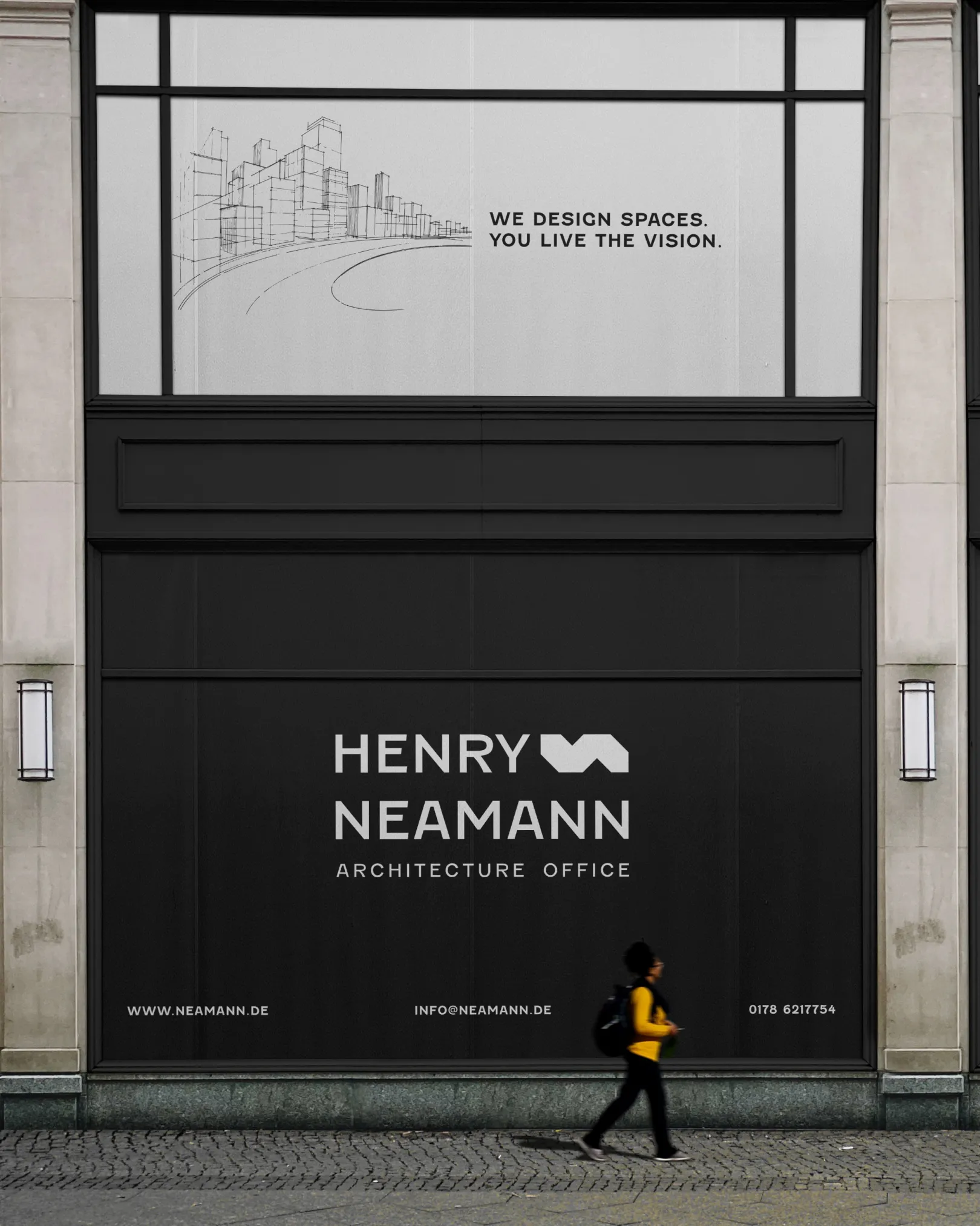 Fassade des Henry Neamann Architecture Office mit Slogan „We design spaces. You live the vision.“ und Architekturzeichnung einer Skyline