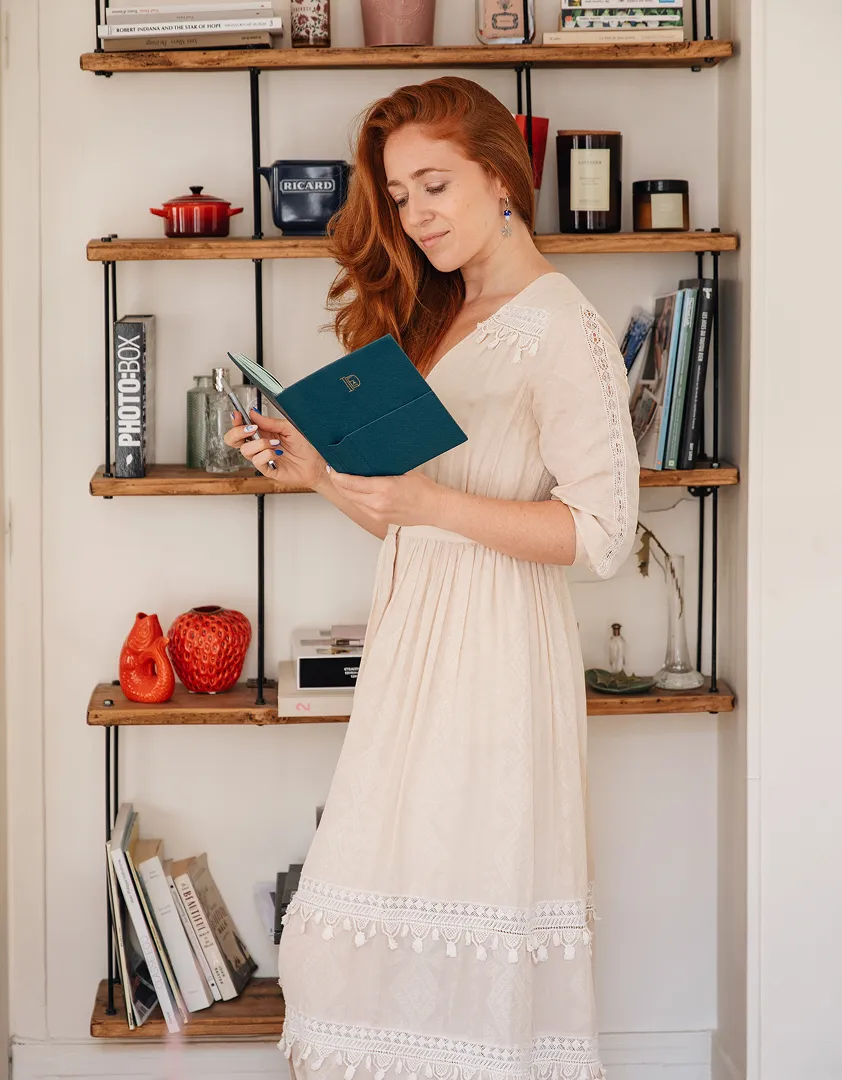 Meredith detko coach, psychedelic guide and rebranding designer for entrepreneurs & lawyers reading in front of book shelf for remote coaching for psychedelic integration