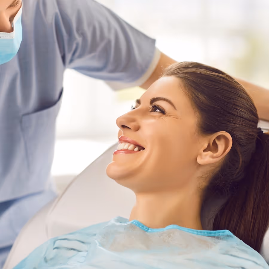 A woman sitting in a dentist chair smiling.