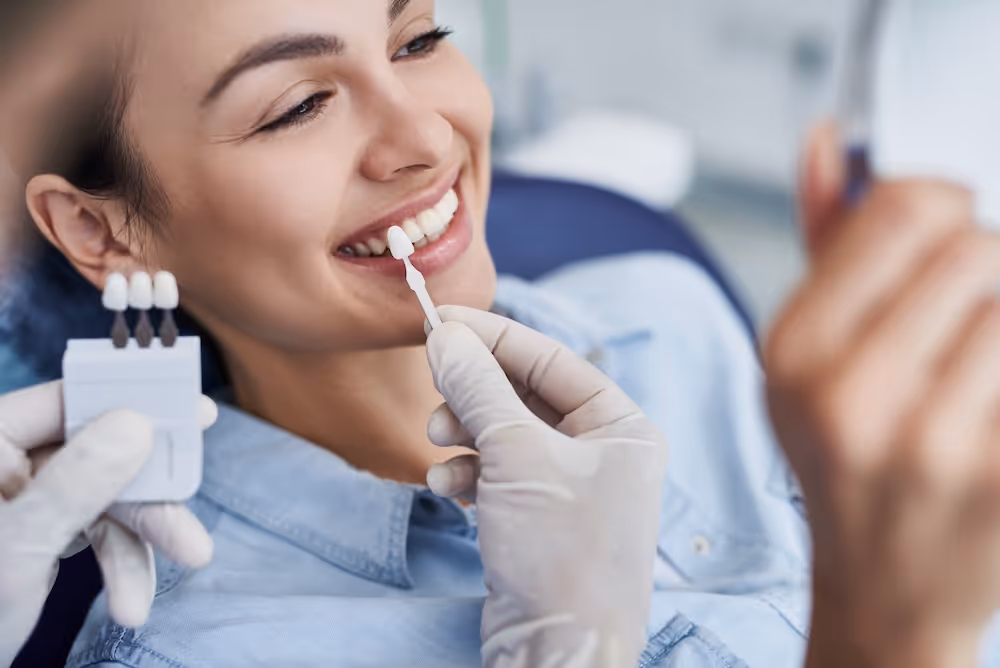 A woman sitting in a dentist chair looking in a mirror.