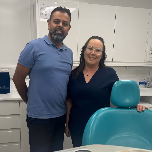 A man and a woman standing in a dental room.