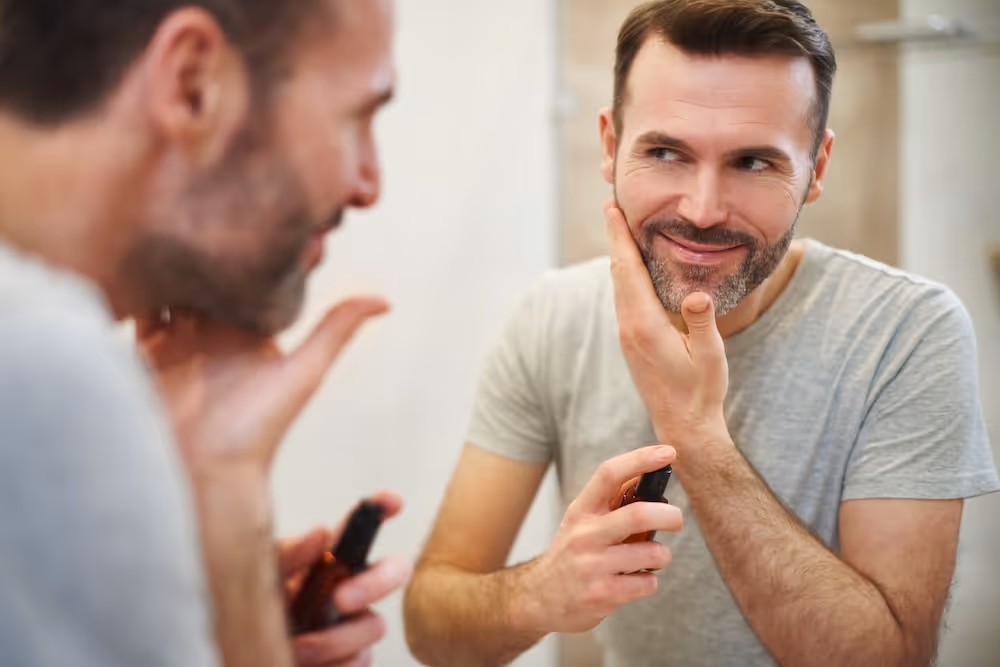 A man looking at his reflection in the mirror.