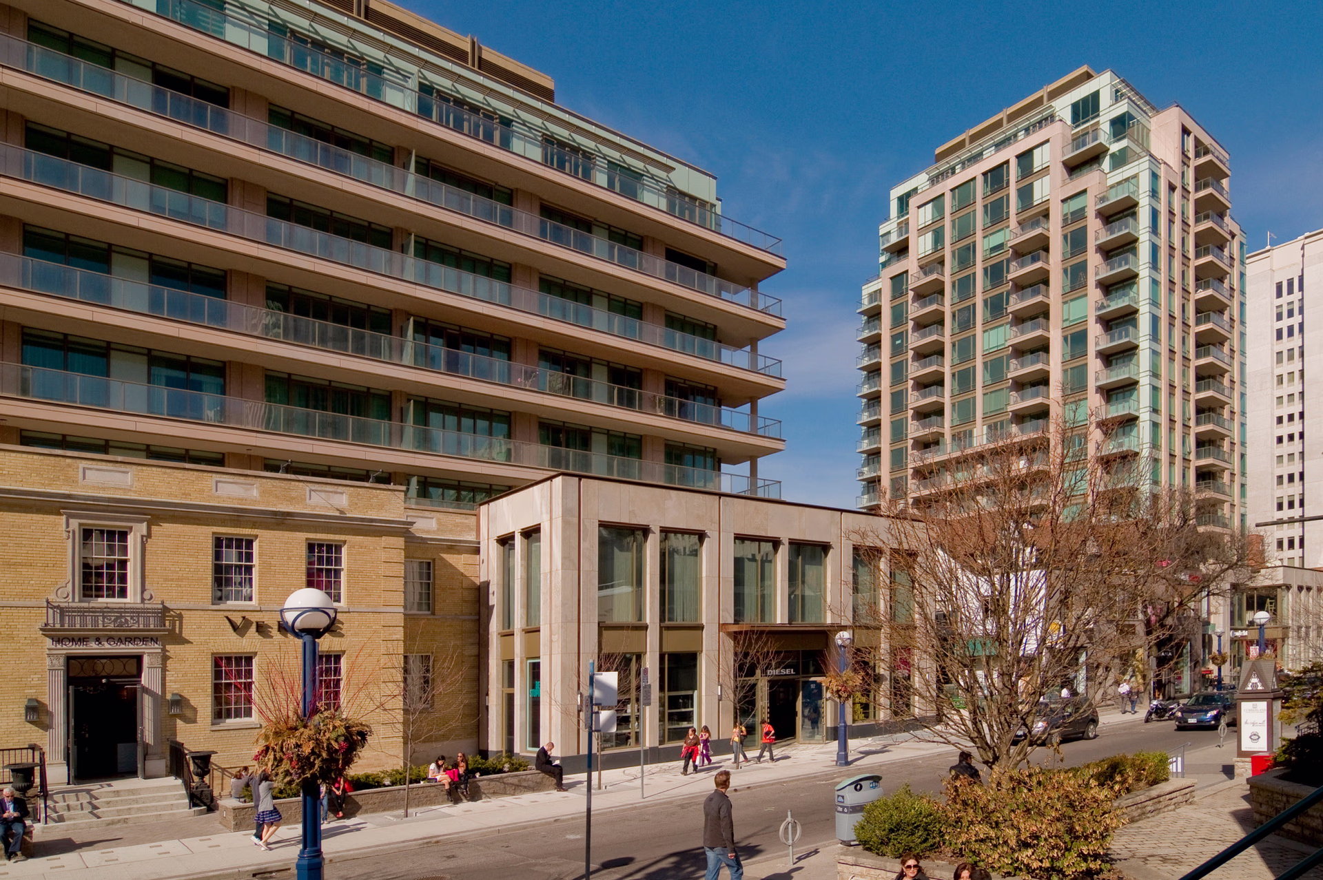 Street-level view of the development showing the restored Mount Sinai Hospital façade beside the contemporary residential building.