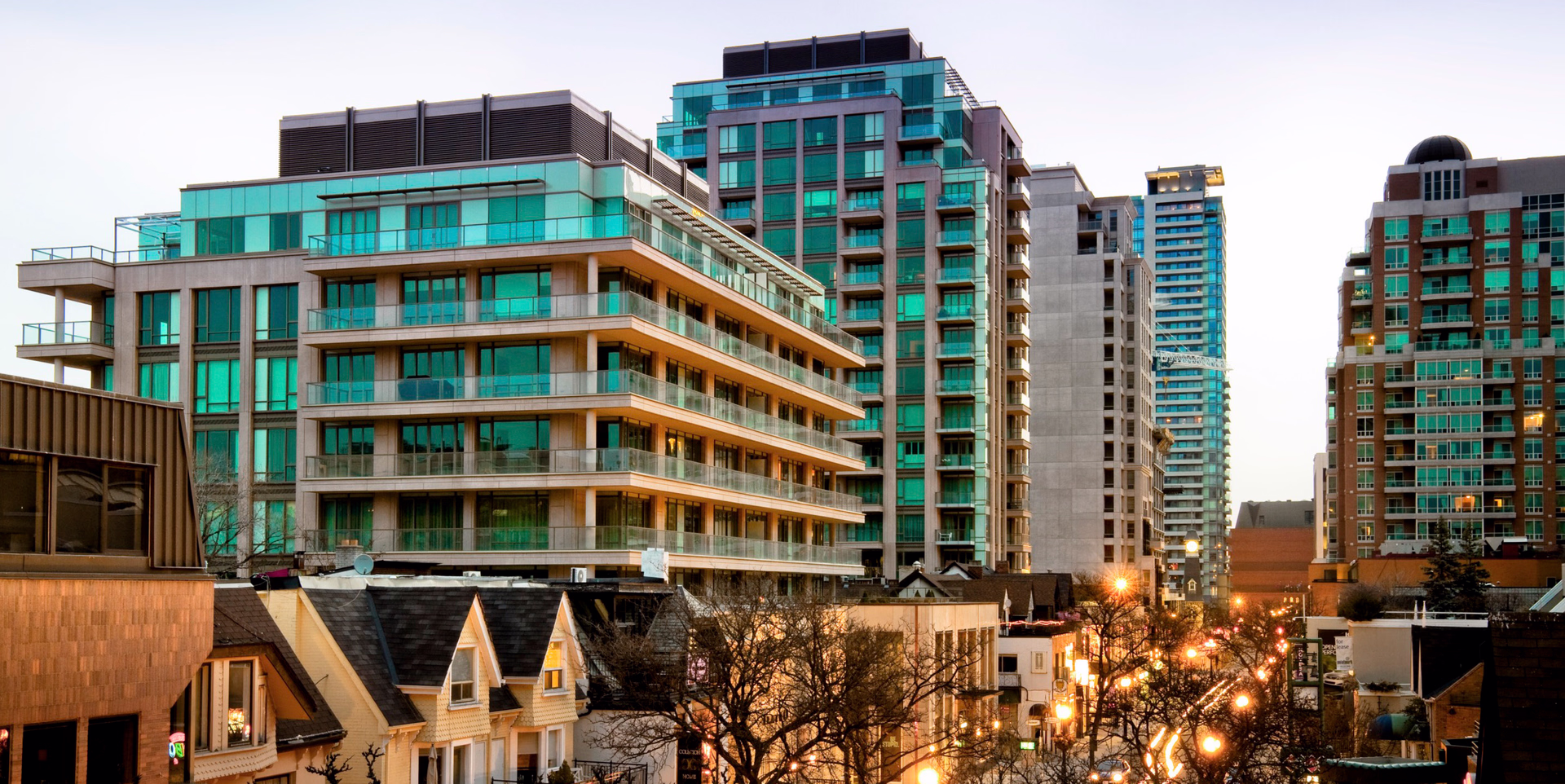 Streetscape view of mid-rise condominium buildings rising above the low-rise Yorkville neighbourhood.