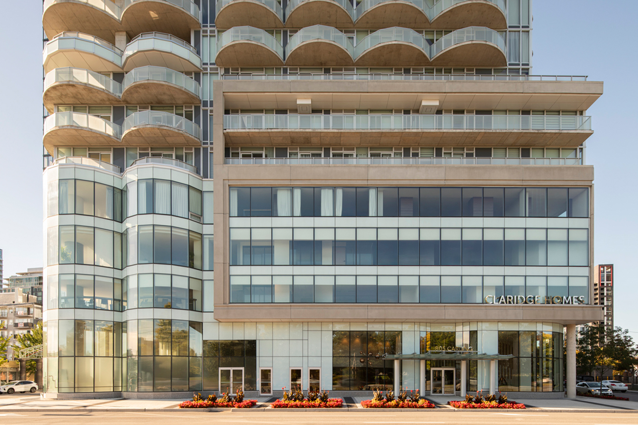 Modern multi-story residential building podium with large windows, labeled Claridge Homes.