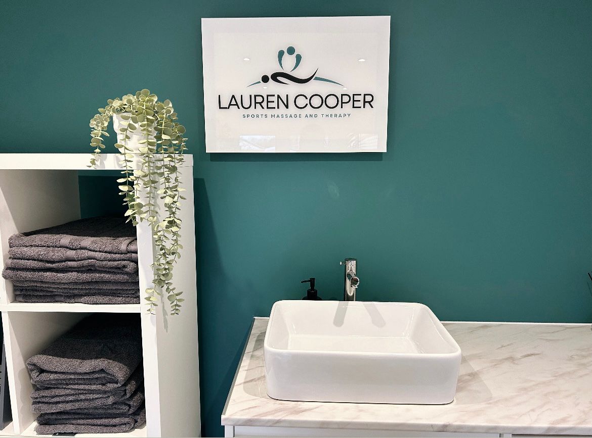 Sink, towel storage, and sign with Lauren cooper's logo on