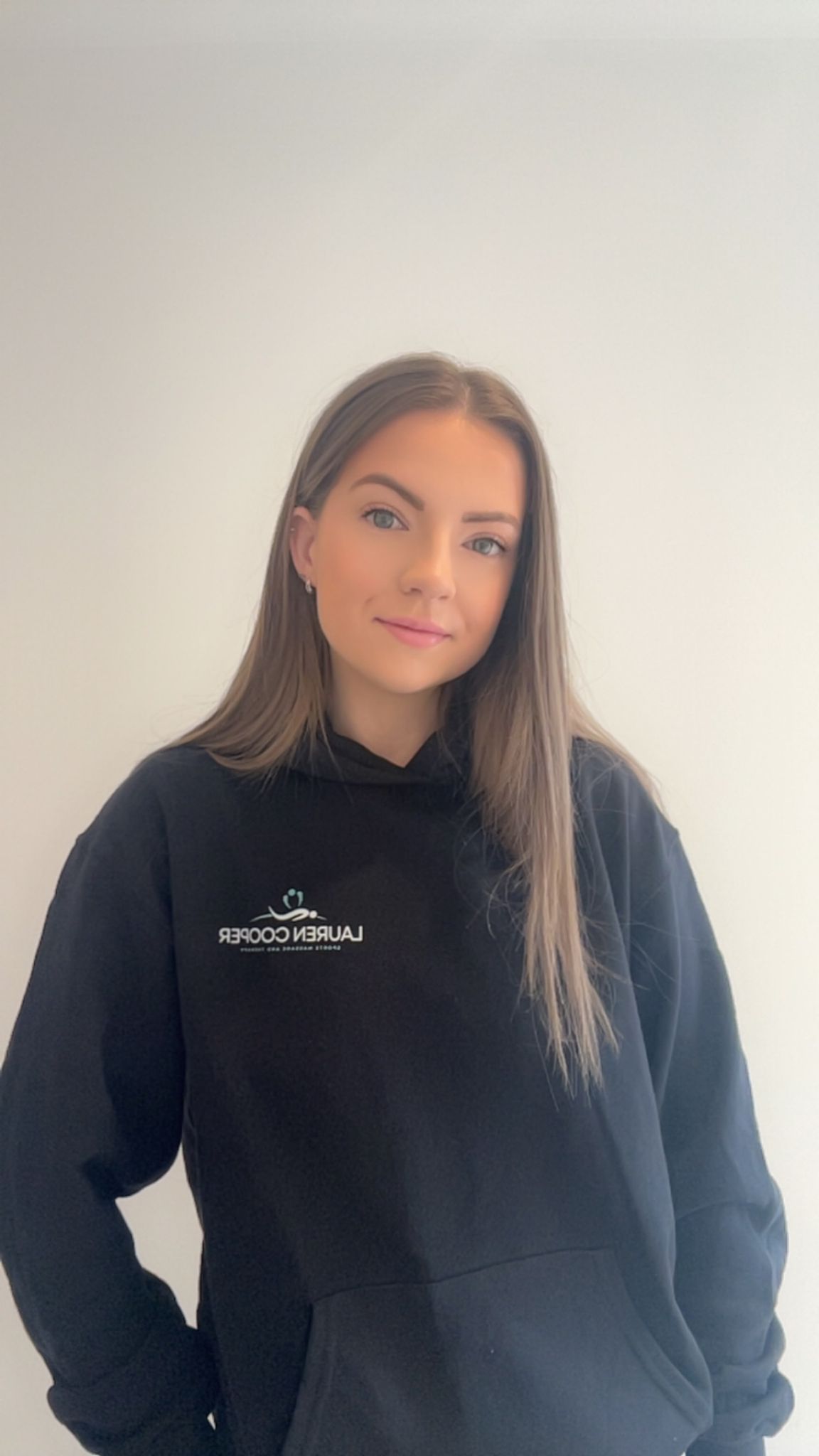 A portrait shot of Lauren Cooper from waist high up wearing a bueiness branded jumper.