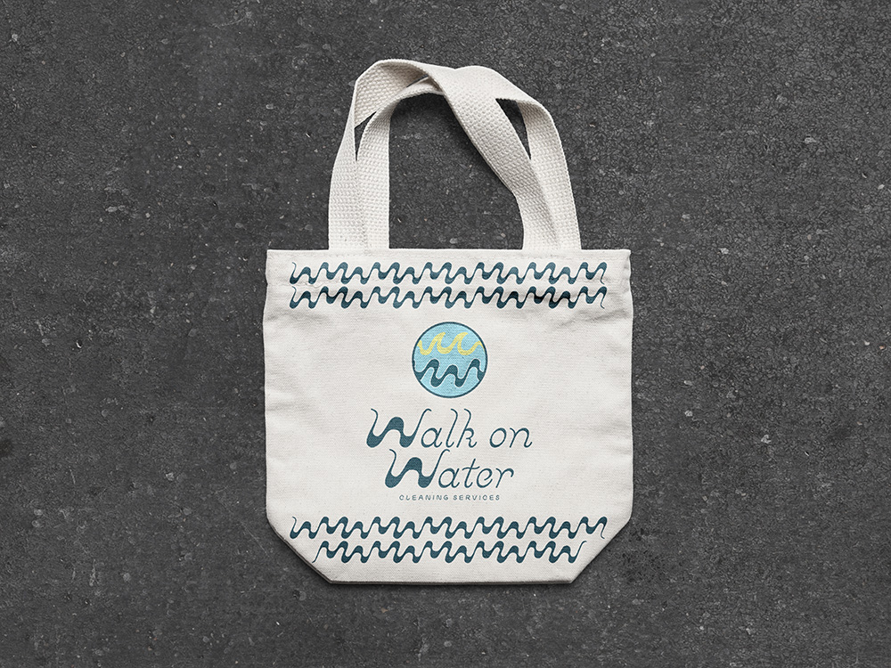 White canvas tote bag with blue wave designs and logo reading 'Walk Water Cleaning Services LLC' on a dark textured background.