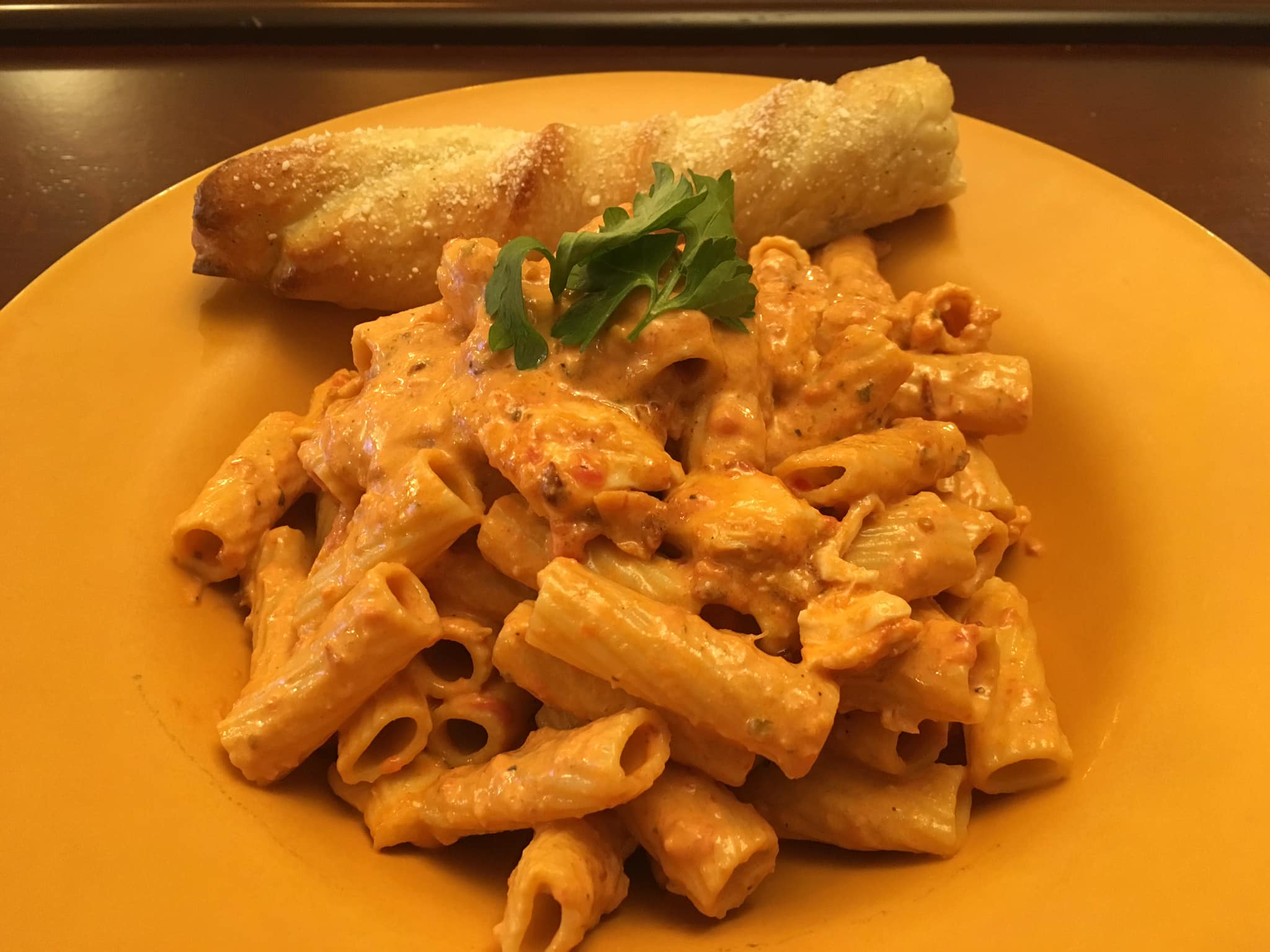 A plate of pasta with a green garnish.