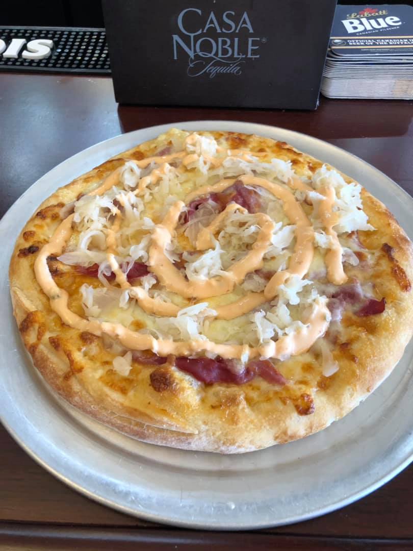 A pizza with cheese and sauce on a white plate.