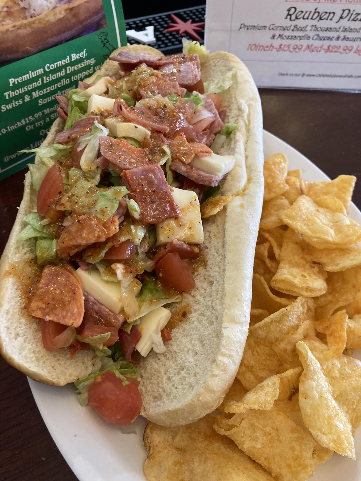 A hot dog with tomatoes and onions on a bun.