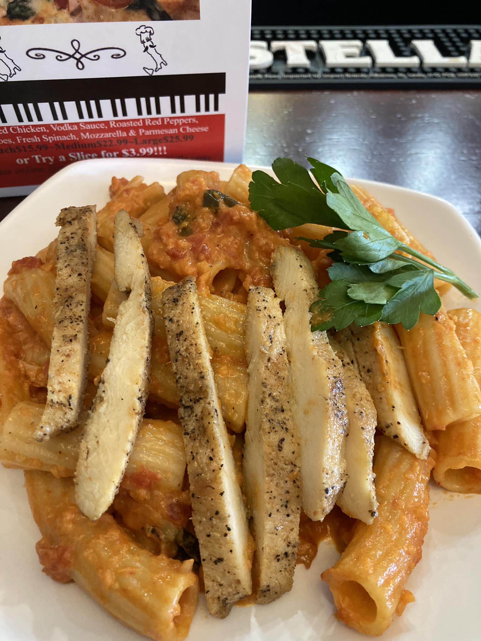 A plate of pasta with chicken and vegetables.