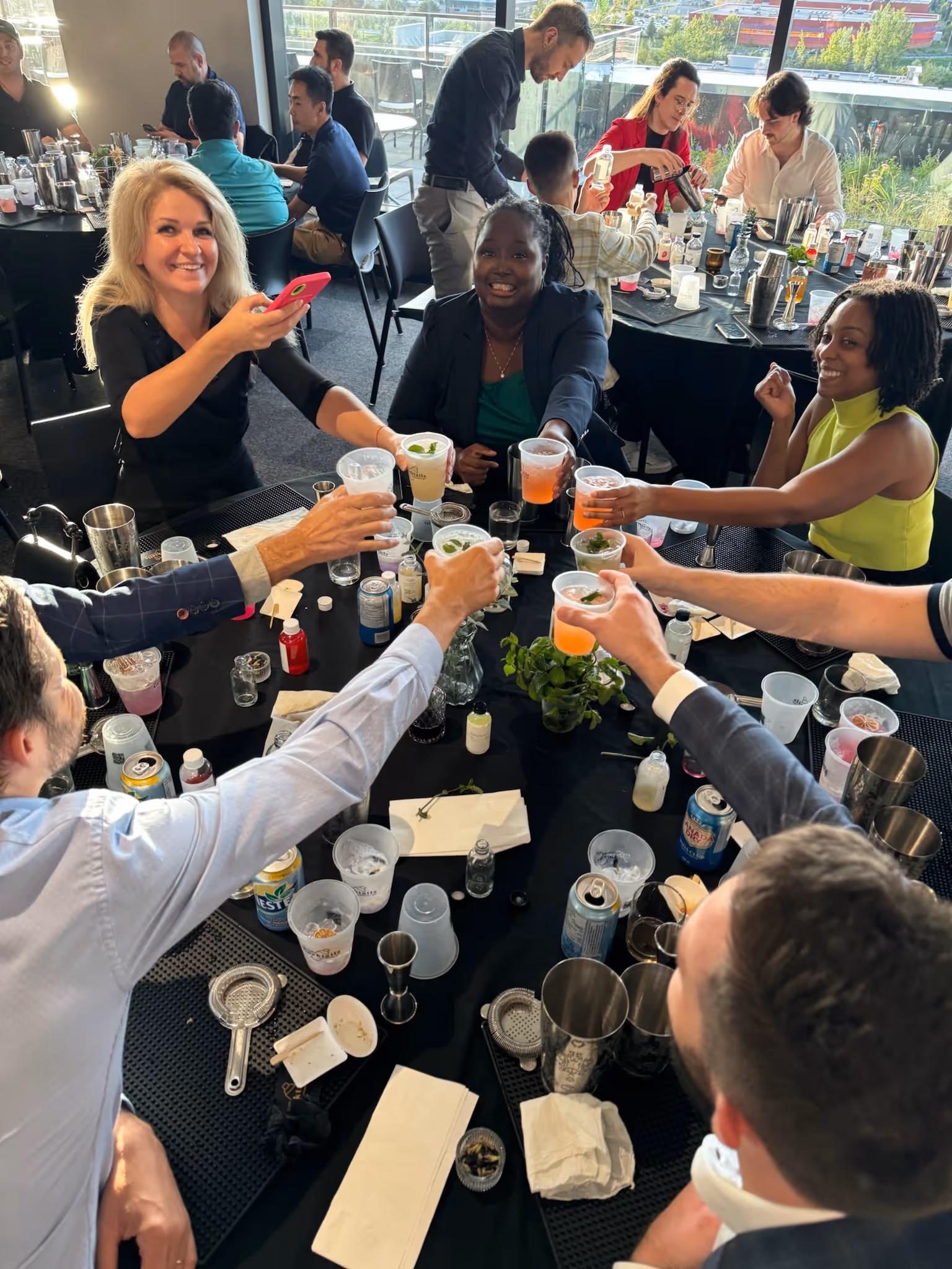 Employees cheering their cocktails made during a team building workshop