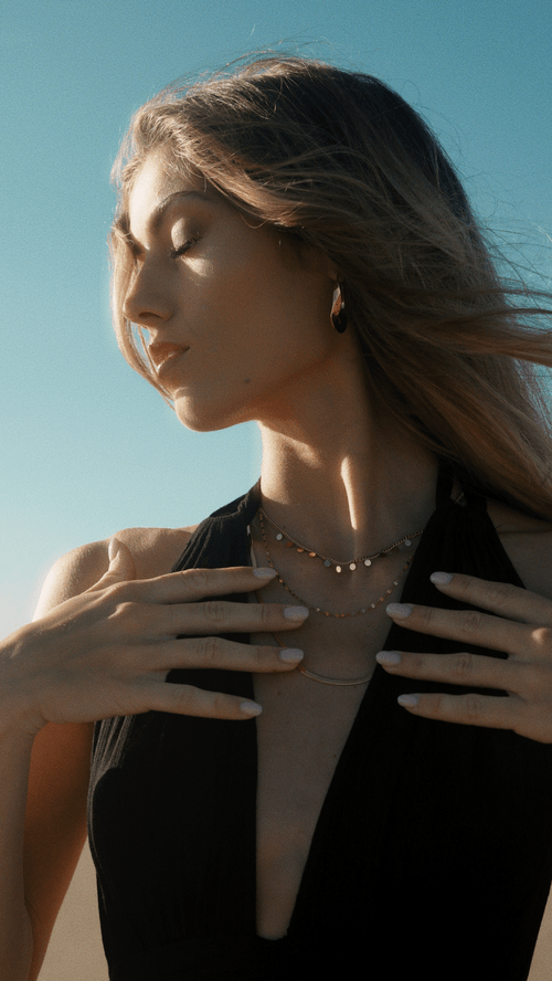 femme qui porte son collier dorée autour du cou