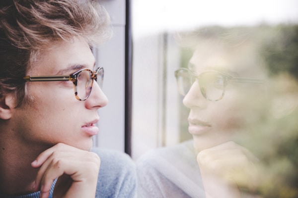 Man looks at reflection in window