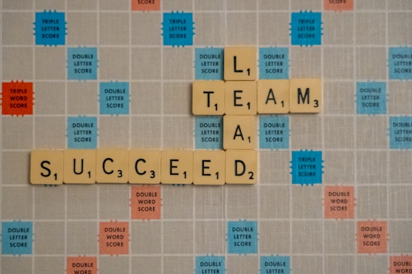 Scrabble board with words Lead, Team Success
