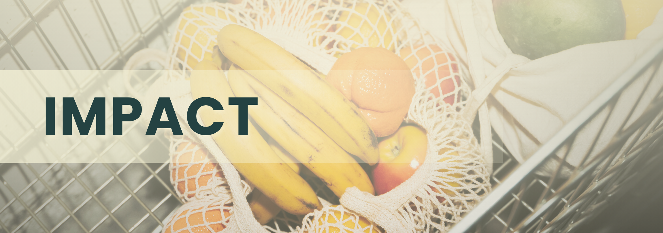 Close up photo of a cart with a bag of bananas, oranges, and apples and the word "Impact"