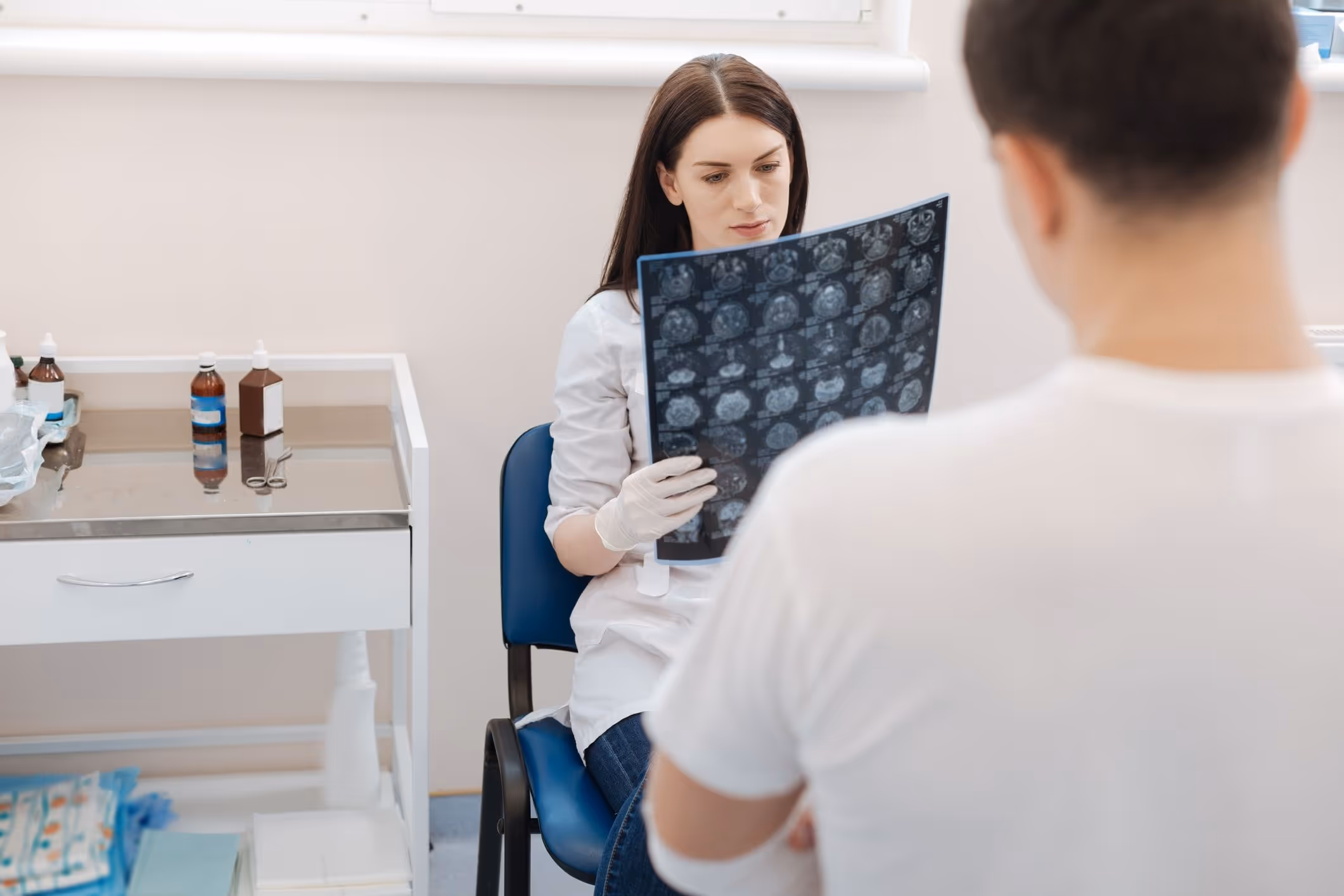 A doctor examining an X-ray to determine the causes of a TBI.