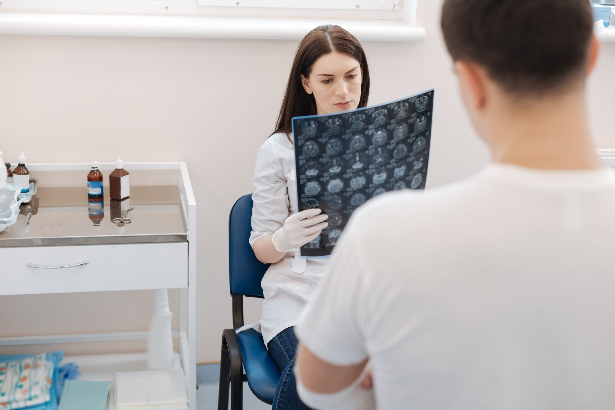 A doctor examining an X-ray to determine the causes of a TBI.