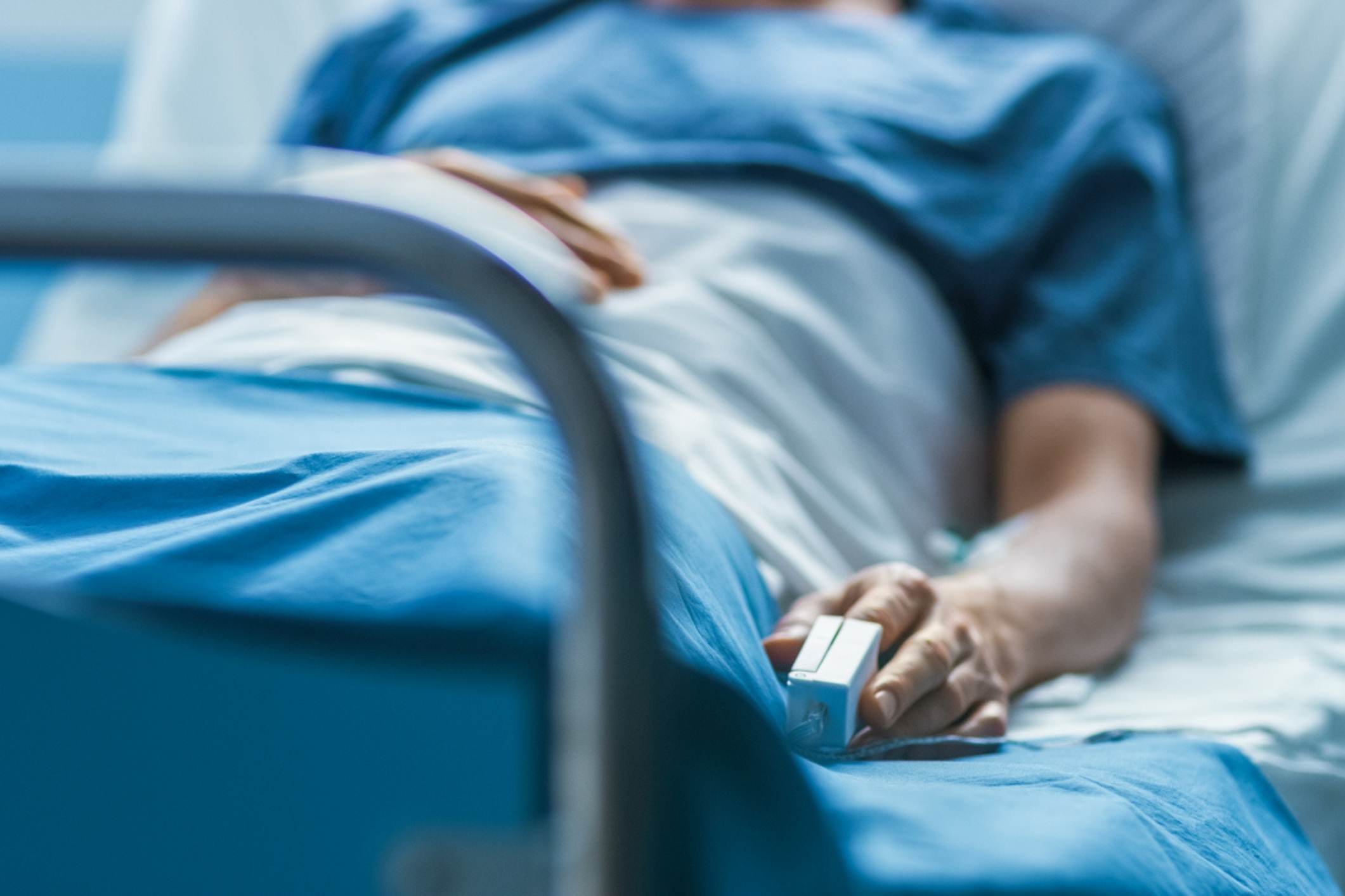 Male hospital patient lying unconscious in bed, representing the need for a coma injury attorney.