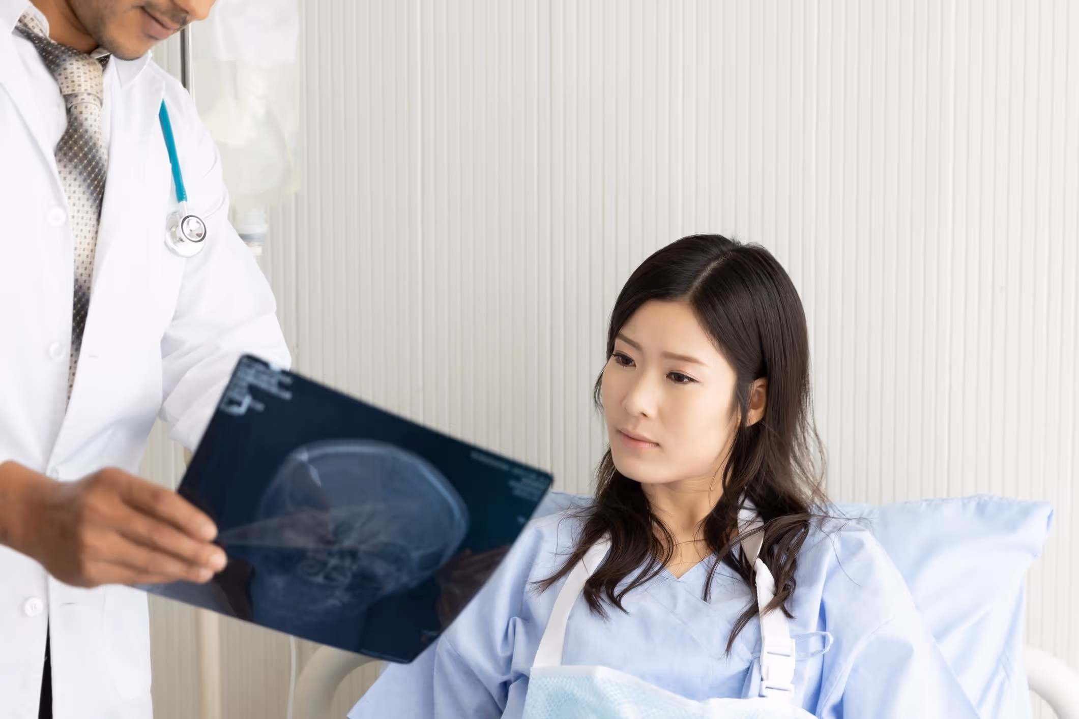 Doctor reviewing brain scan with patient, explaining what happens if the thalamus is damaged.