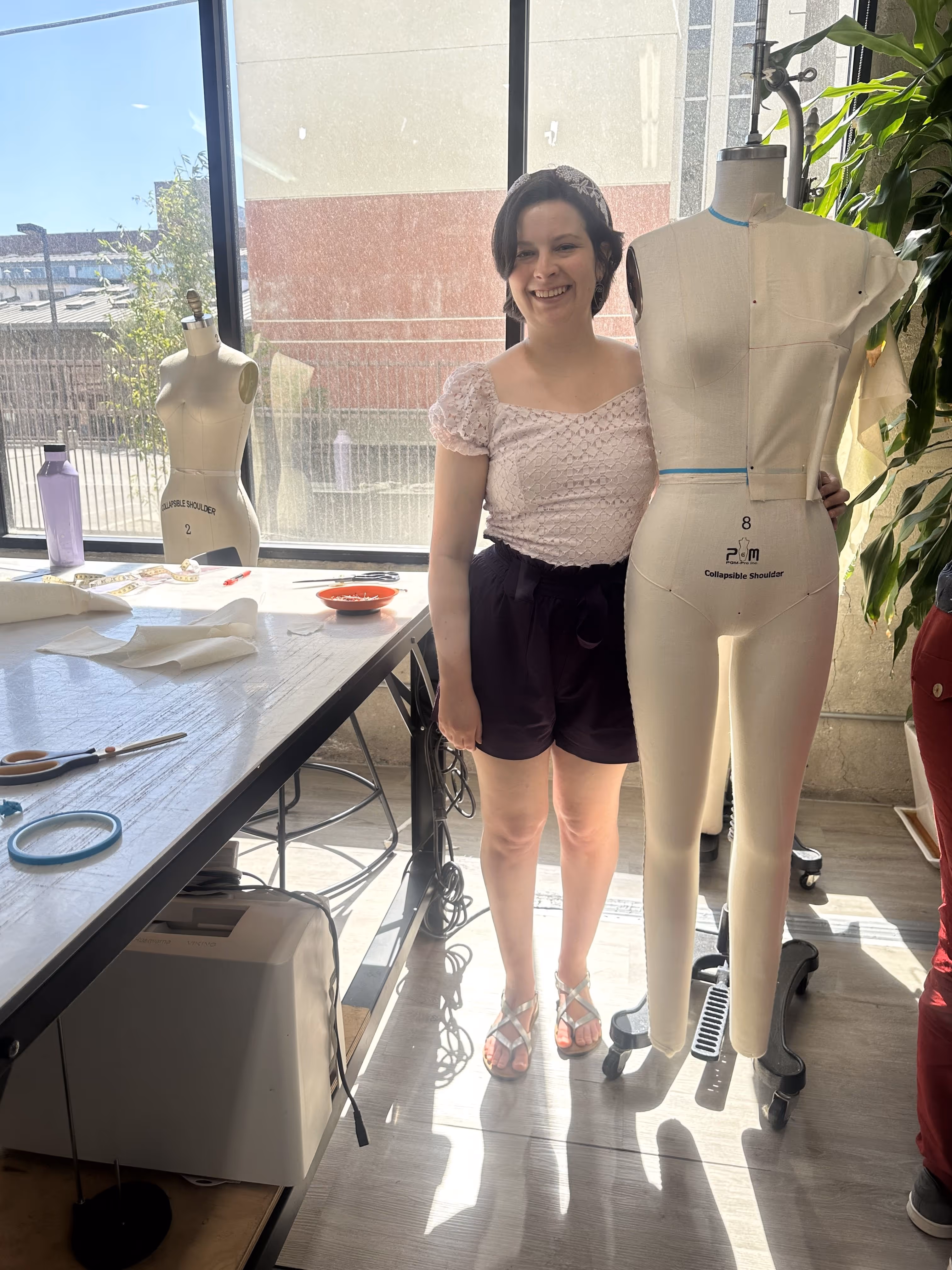 Sierra Henderson standing next to dressform