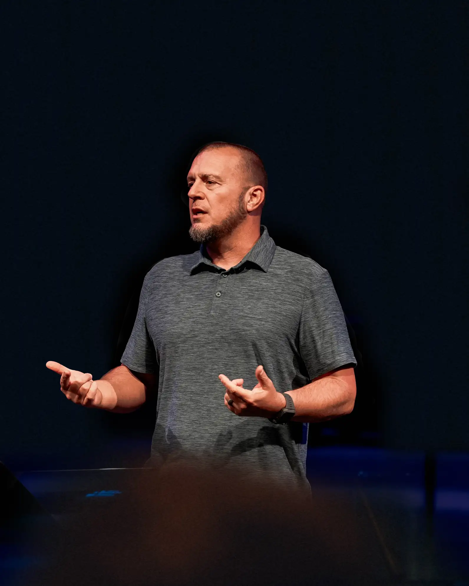 Family Discipleship Pastor speaking on stage with a microphone headset.