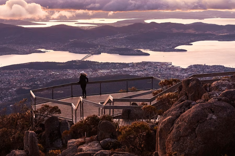 Visitor on the kunanyi / Mount Wellington summit viewing platform at dawn, above Hobart