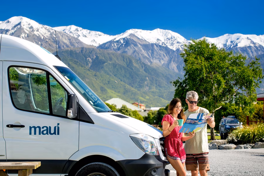 maui campervan on a site with snow-capped ranges behind at Kaikōura TOP 10 Holiday Park