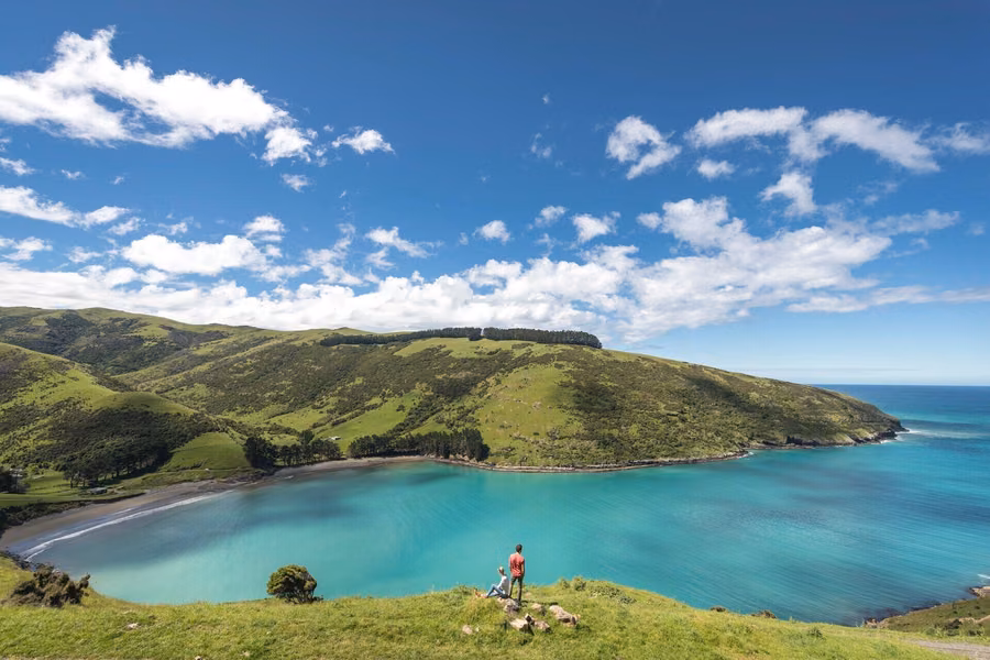 Turquoise bay below green hills on Banks Peninsula near Akaroa