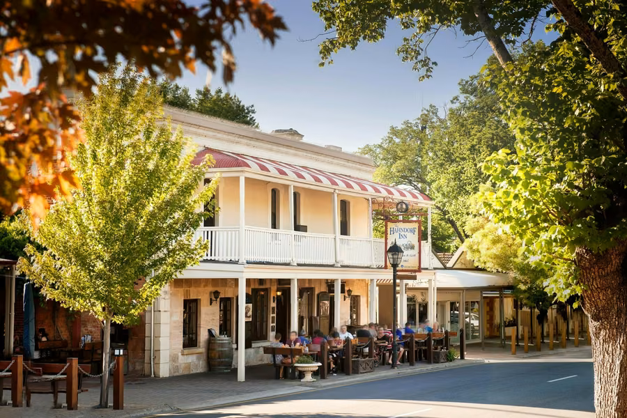The Hahndorf Inn's balcony and striped awning above outdoor diners on Hahndorf's tree-lined main street