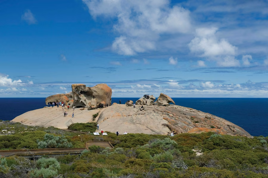 Visitors exploring the Remarkable Rocks on a granite dome above the Southern Ocean on Kangaroo Island