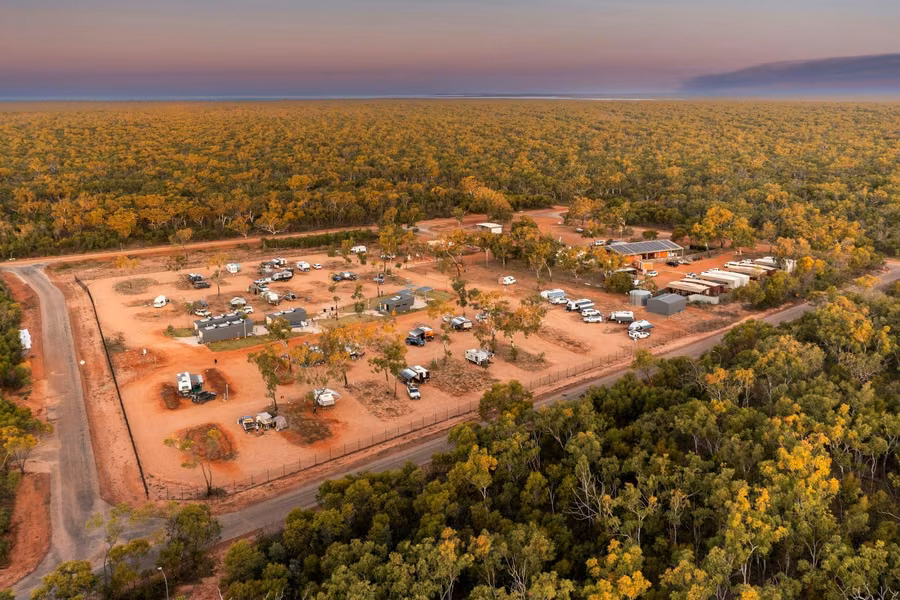 Aerial view of Djarindjin Campground's red-dirt sites surrounded by pindan woodland at dusk