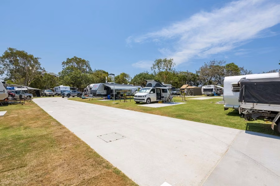 Campervan and caravans on grassy powered slab sites at Mooloolaba Beach Holiday Park