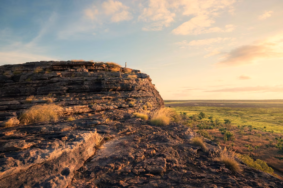 Sandstone outcrop at Ubirr glowing at sunset above the green floodplains of Kakadu National Park