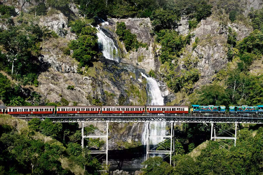 Kuranda Scenic Railway train crossing the bridge in front of Stoney Creek Falls in the rainforest