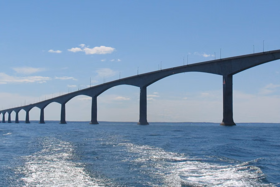 The Confederation Bridge's arched concrete spans stretching across the Northumberland Strait under a blue sky