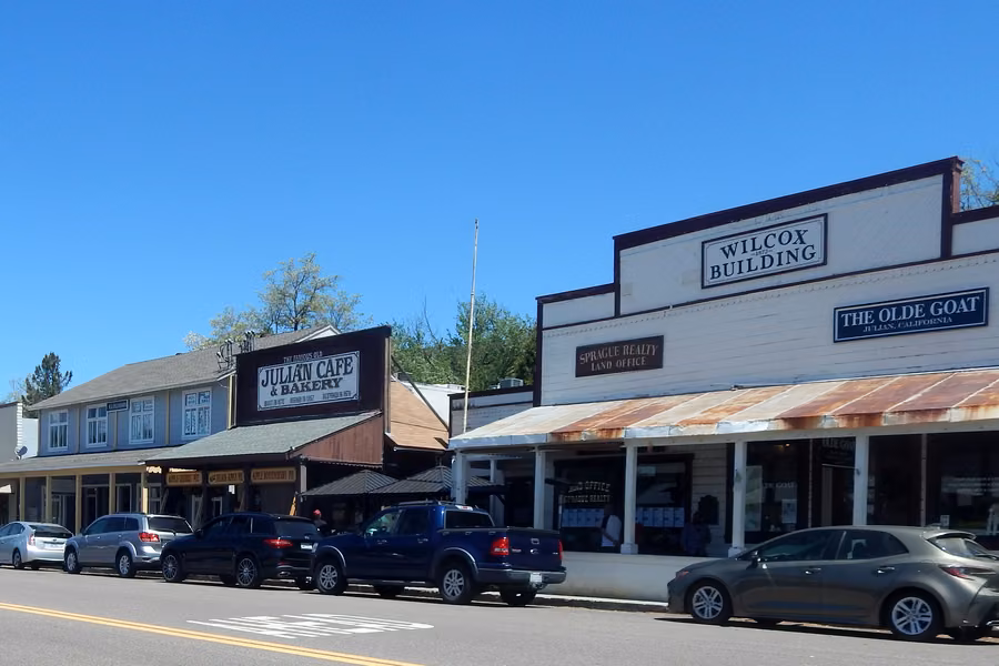 Timber shopfronts with verandahs along Main Street in the old gold-mining town of Julian under a blue sky